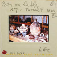 A photograph of a table with various pottery items, including vases and bowls.