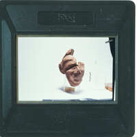 A small, dark brown sculpture of a human head on display.