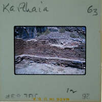 An old stone structure with a weathered appearance, possibly ruins, set against a natural landscape.