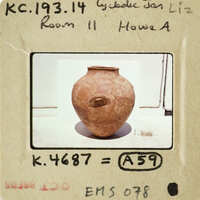 This is an image of a clay pot with a handle, placed on a surface.