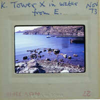 Picture of a rocky shoreline with water and boats, taken from an old film strip.