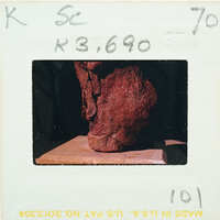 A photograph of a red, jagged rock on display with an information card.