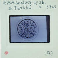 A circular metal object with intricate designs, possibly a seal or emblem