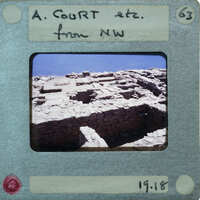 Old photograph of a stone ruins with a label and date on the front.