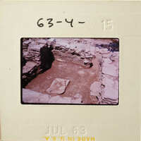 Old photograph of an excavated archaeological site with stone ruins and dirt, dated July 63.