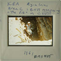 A person standing at the entrance of an underground cave with natural rock formations.