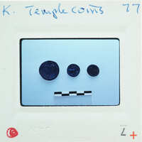 Three coins with a face-like arrangement on a white surface.