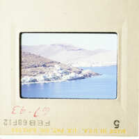 This is an image of two photos placed side by side, showcasing a scenic view of a coastal town with a body of water and mountains in the background.