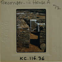 Photo of a stone structure with a white roof on a film strip.