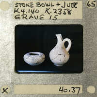 The image shows a photograph of two ancient pottery pieces, a stone bowl and a jug, with visible signs of wear such as cracks and discoloration.