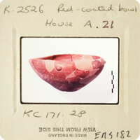 A photograph of an antique red clay bowl with visible cracks and imperfections, displayed on a card labeled "House A" with handwritten notes.